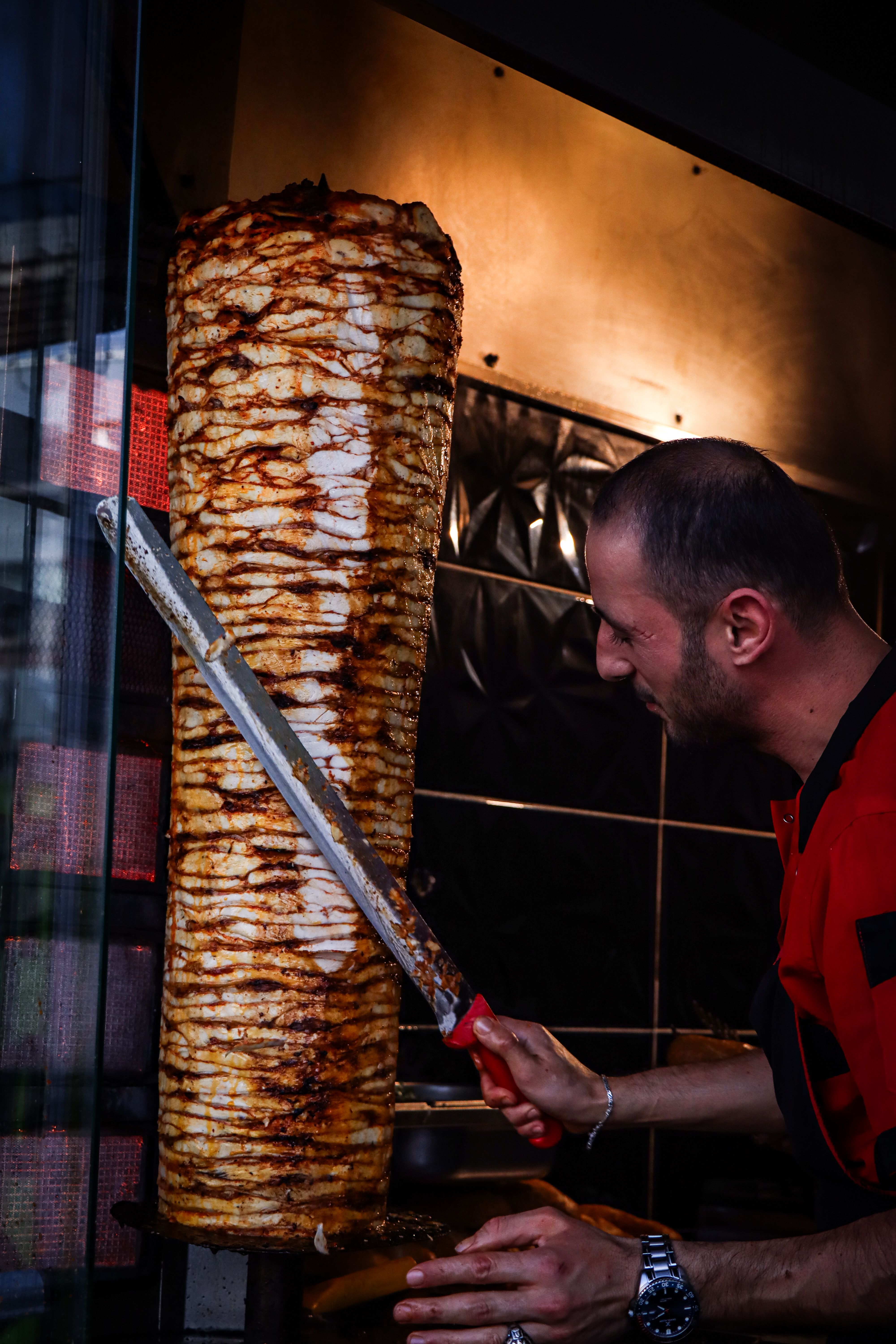 Handwerk und Qualität im Dönerladen Berlin Frischer Döner wird direkt vom Spieß geschnitten